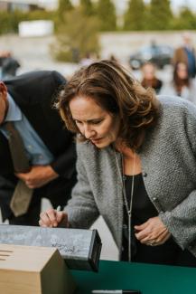 Secretary Tanner Signing a metal building beam